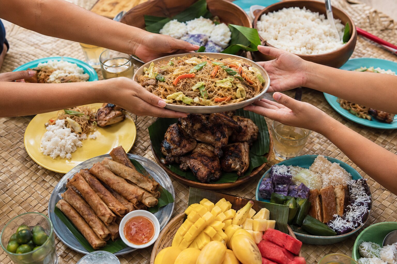 Guests sharing Filipino dishes around a colourful communal fiesta table